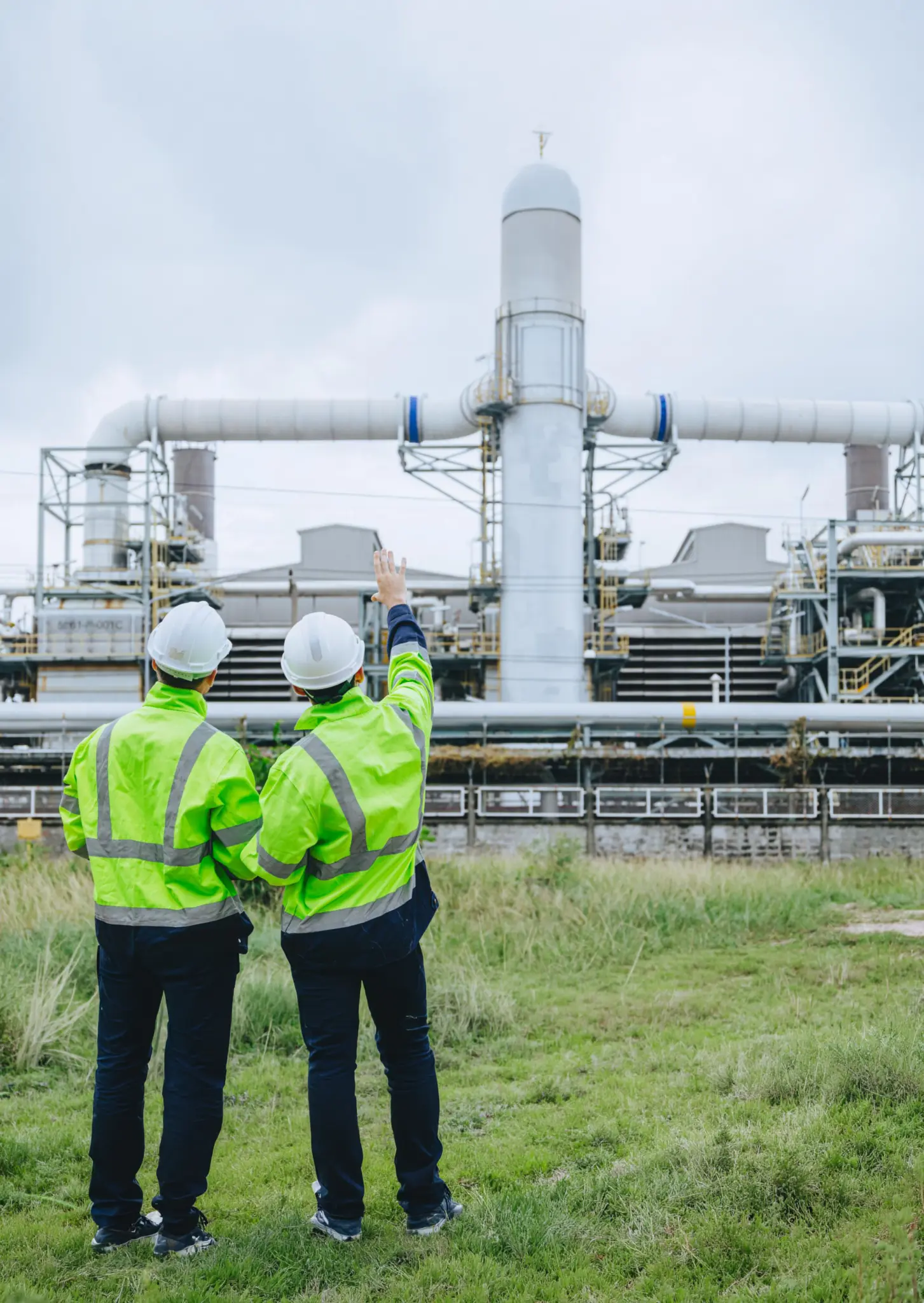Two Al Yusr Middle East engineers in hi-vis jackets and hard hats inspecting an industrial plant facility in Saudi Arabia