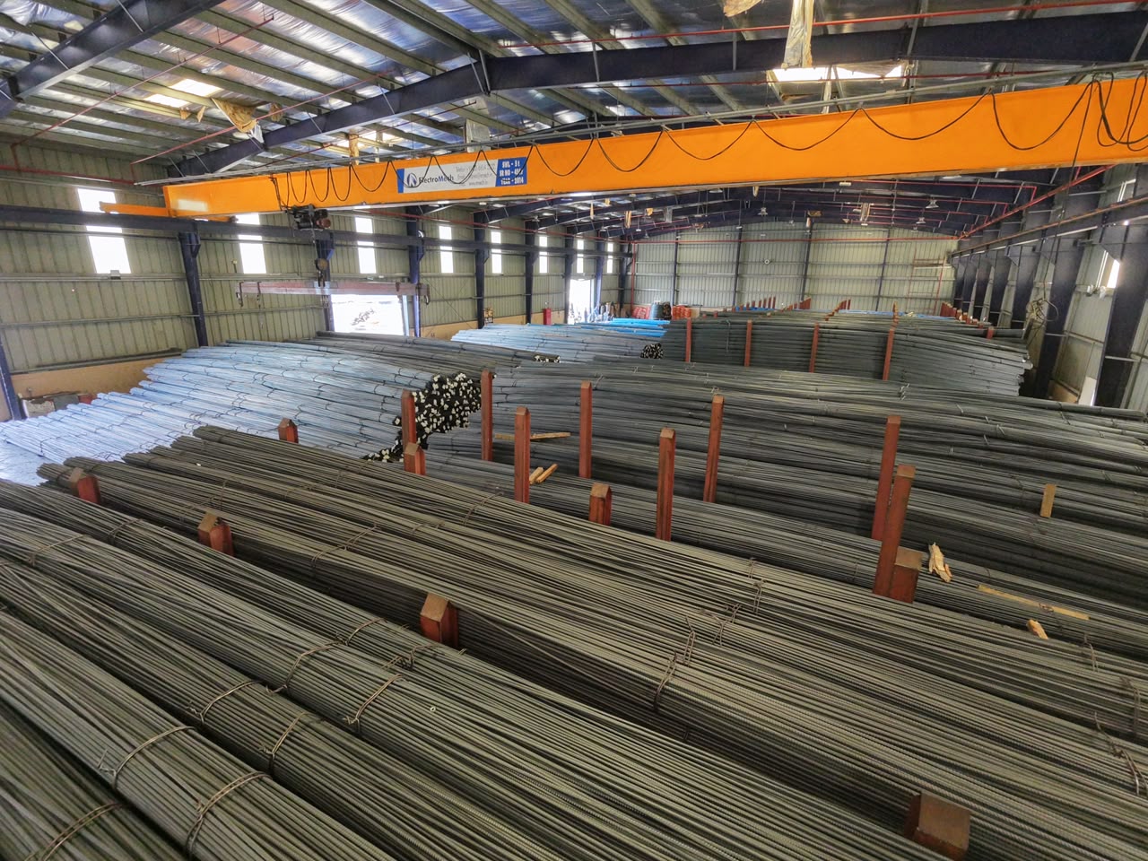 Steel rebar bundles and overhead crane inside the Sohar branch warehouse